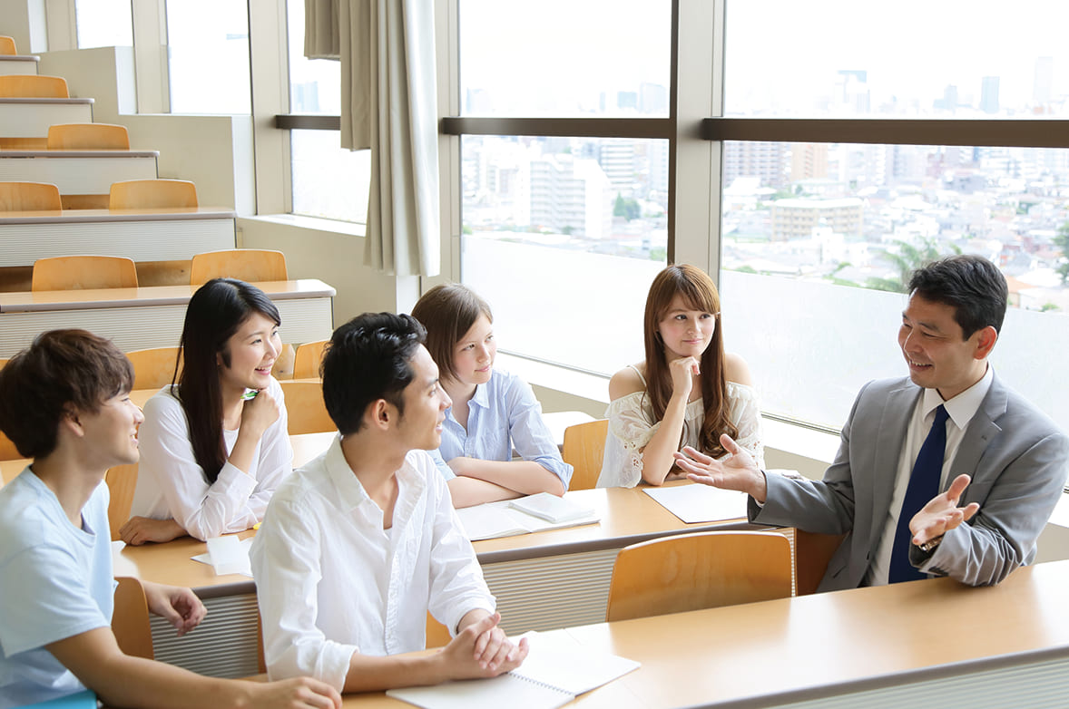 教員と会話をする学生たちの画像
